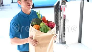 穿蓝色制服的送餐服务人员。 泰国送货员为年轻女子提供新鲜食物。